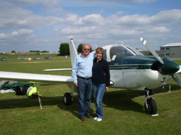 Piper Cherokee G-ATIS on the ground with a man and a woman standing in front.