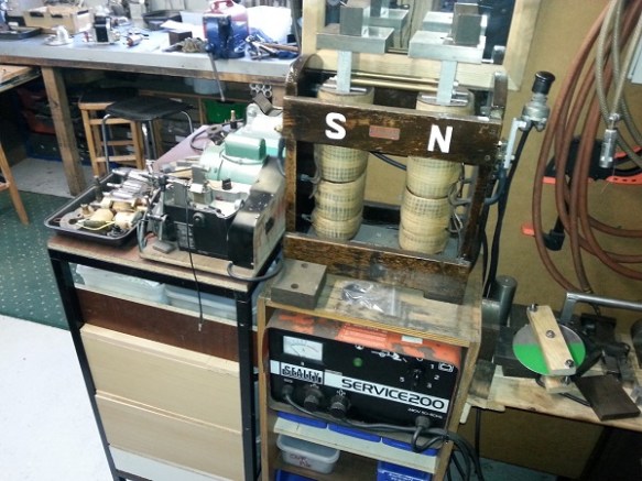 A woodent frame on top of a stack of equipment with two coils labled 'S' and 'N'.