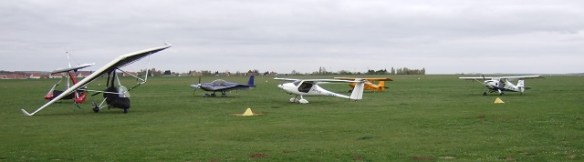 Three aircraft parked on grass.