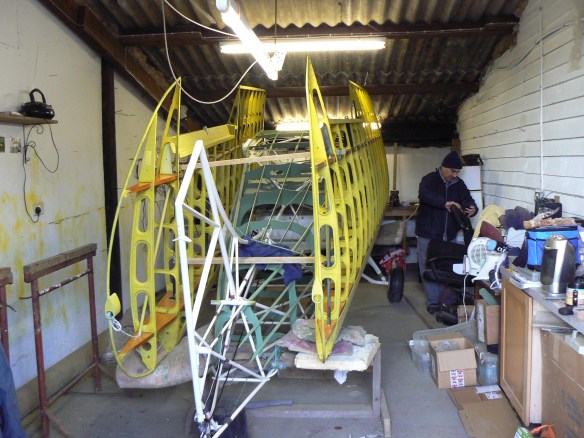 Uncovered aircraft in shed.