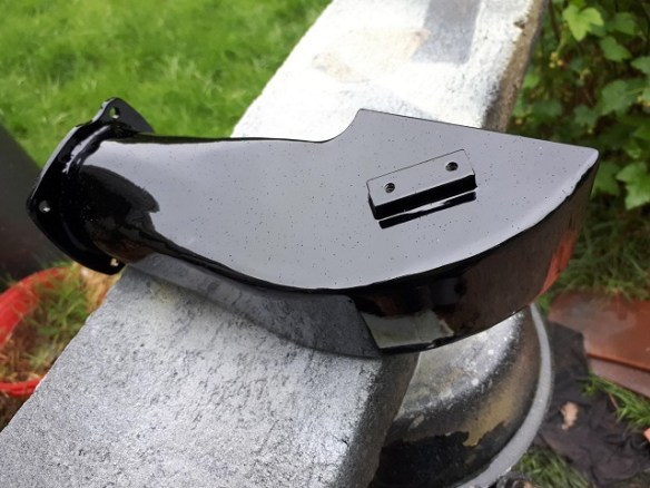 A gloss black painted engine component.