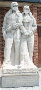 Statues of Alcock and Brown, both fitted with fabric Covid pandemic masks.